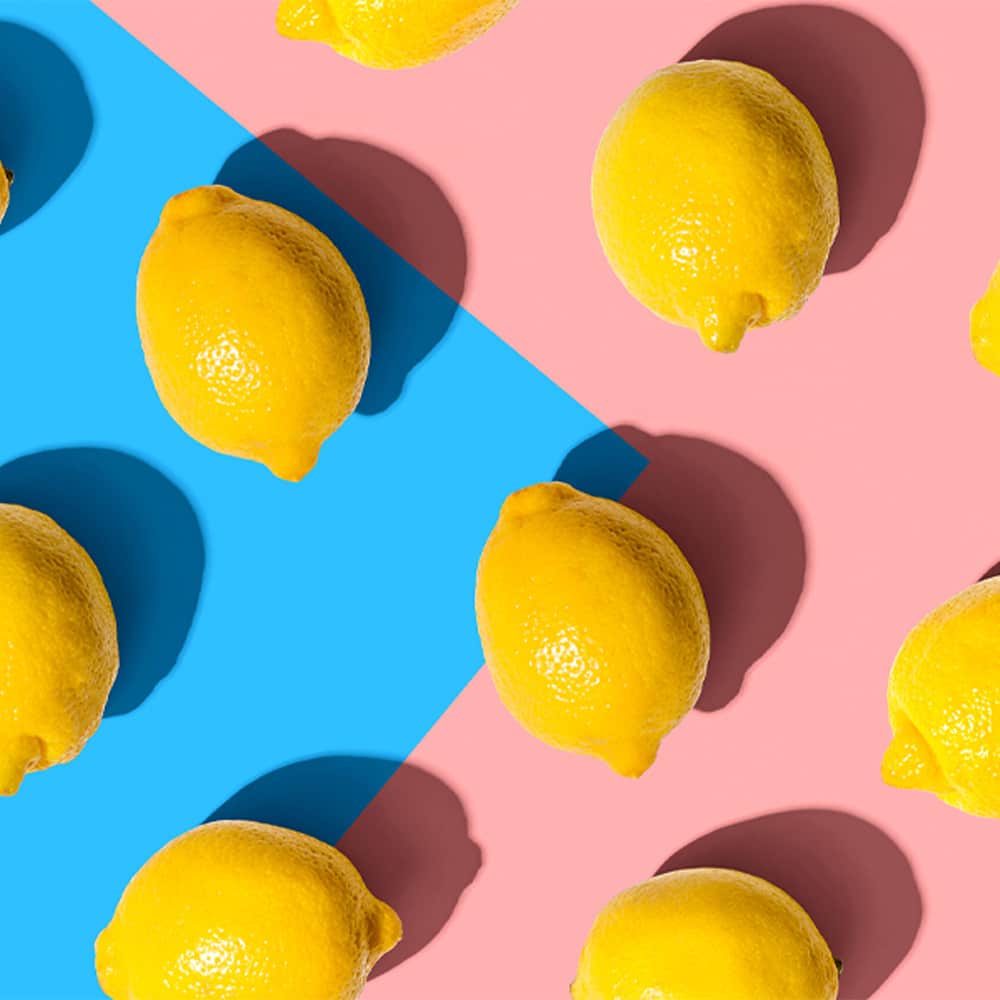 Yellow lemons on bright blue and pink background.