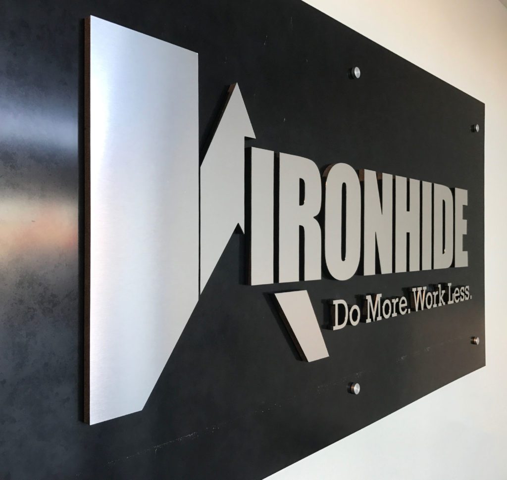A metal sign of Ironhide’s logo on a black wall