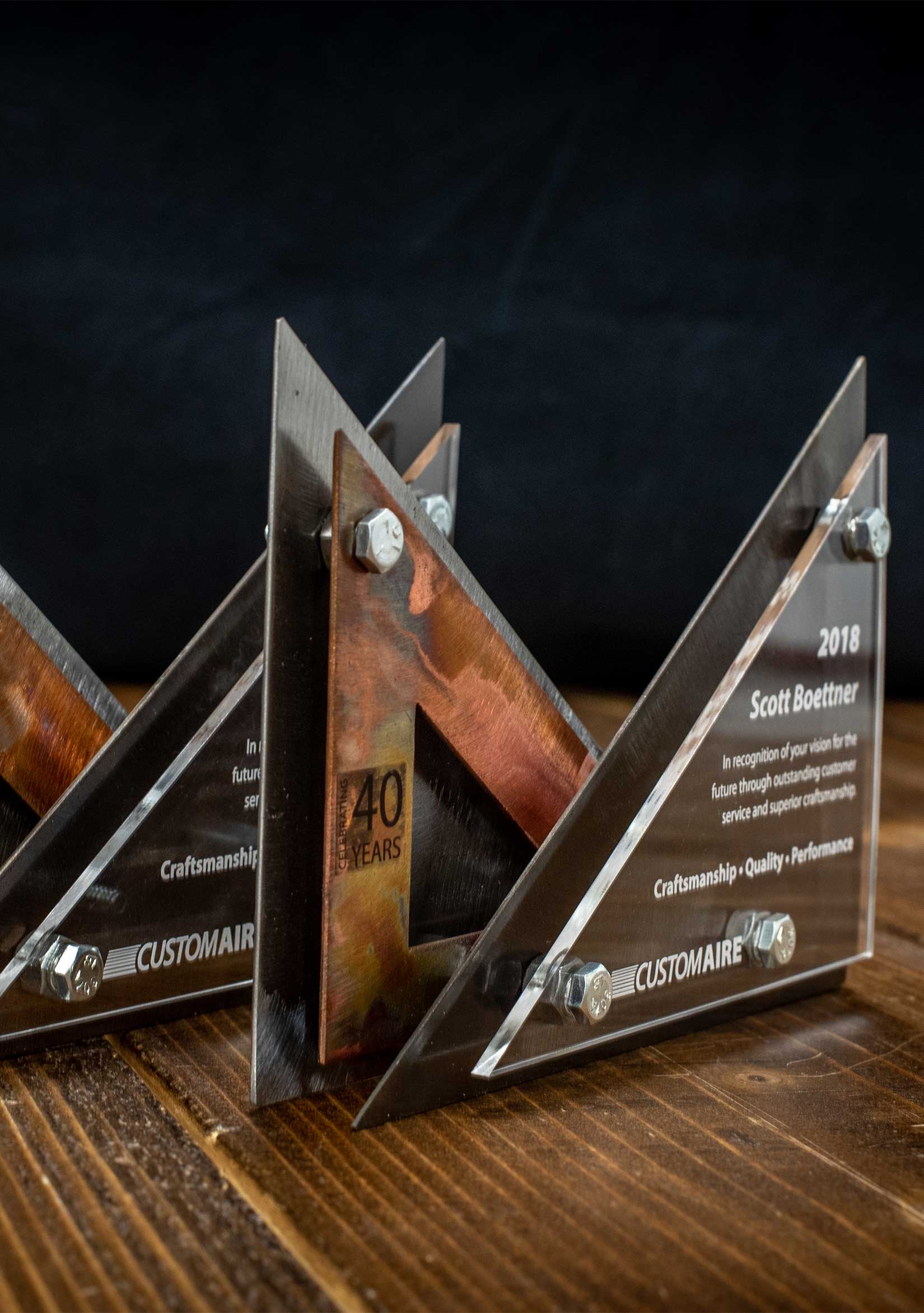 Two metal and triangular awards created for Custom Aire.