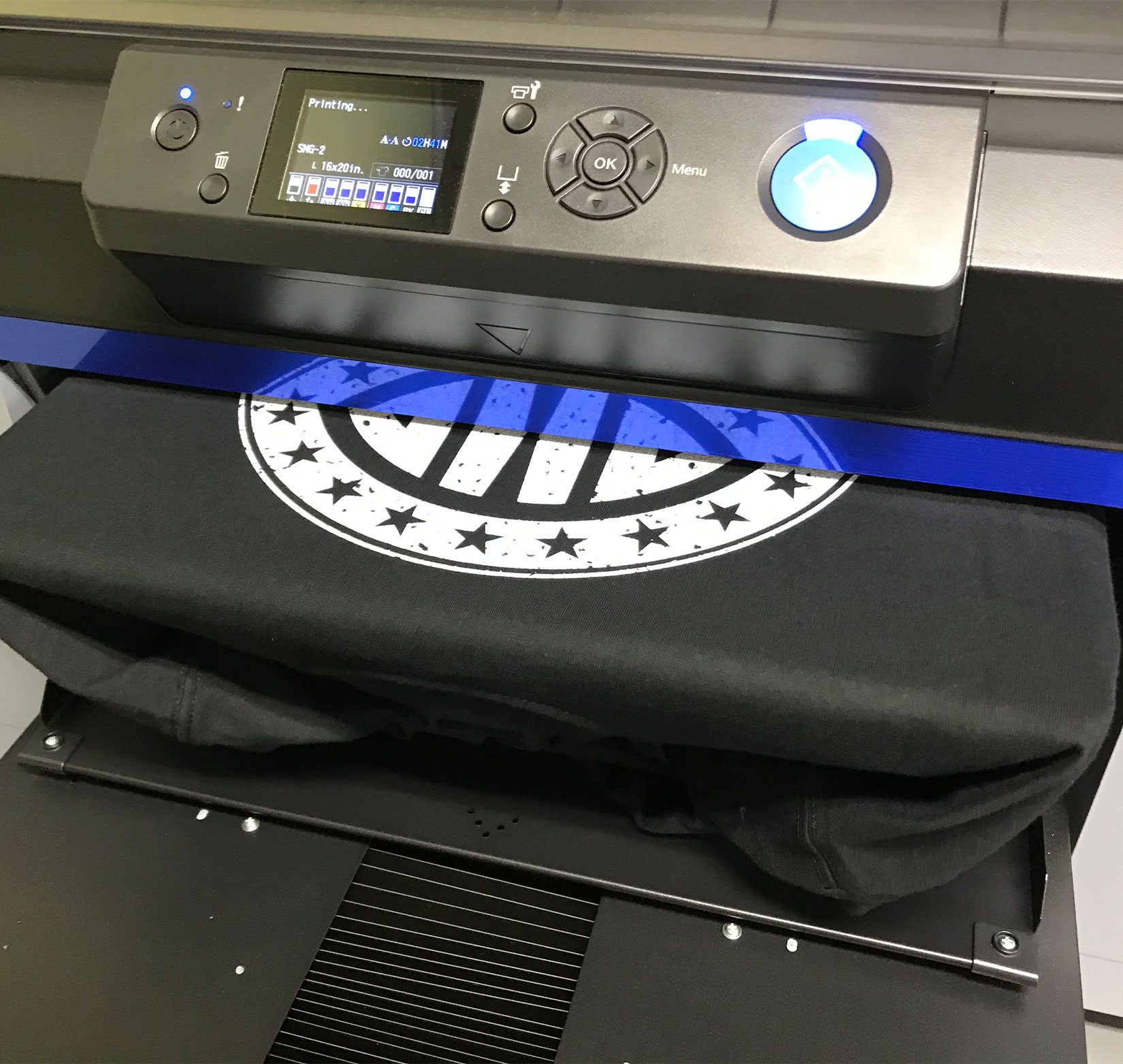 A black t-shirt emerging out of a screen printer