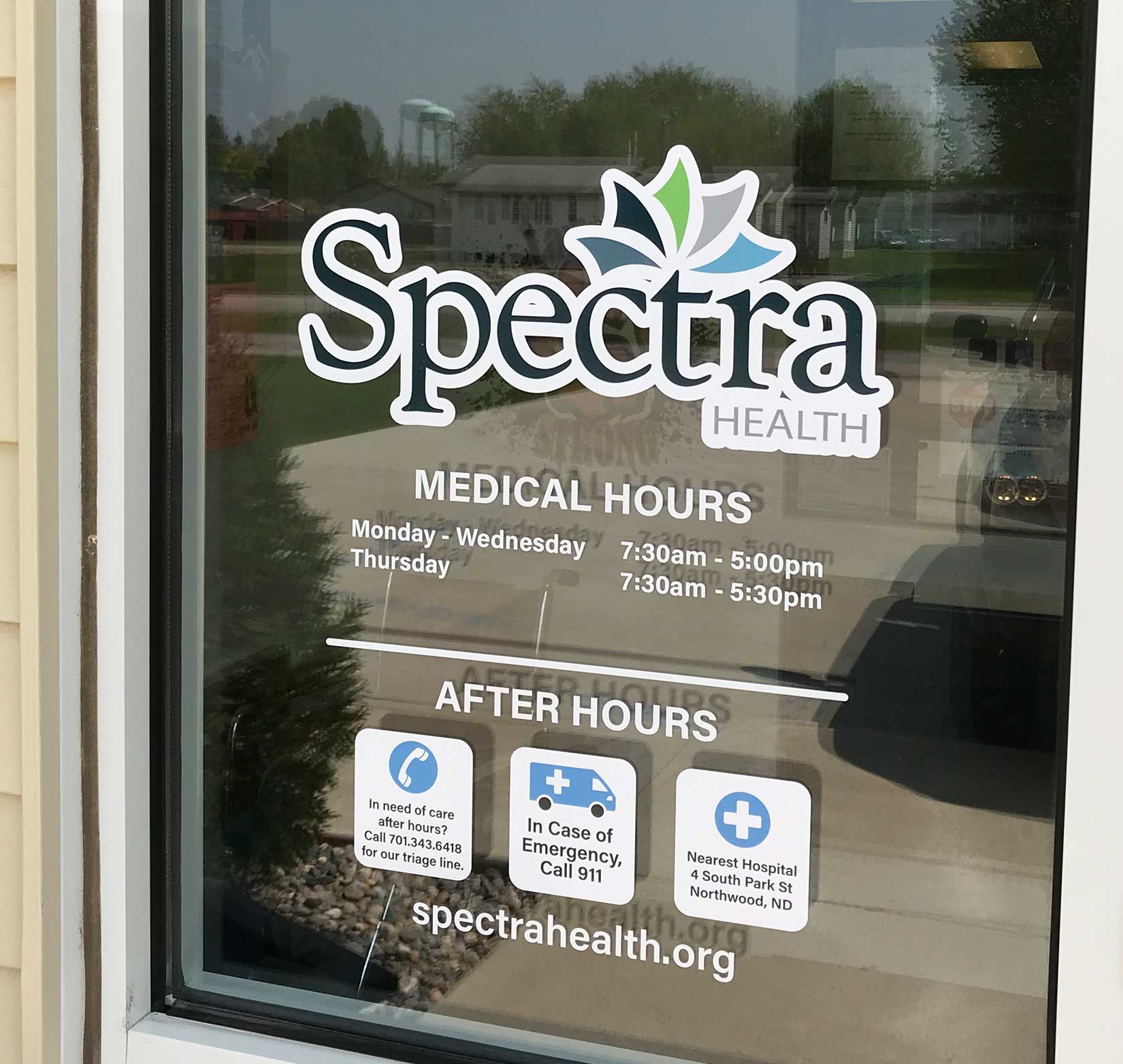 A vinyl sign for Spectra Health installed on a window