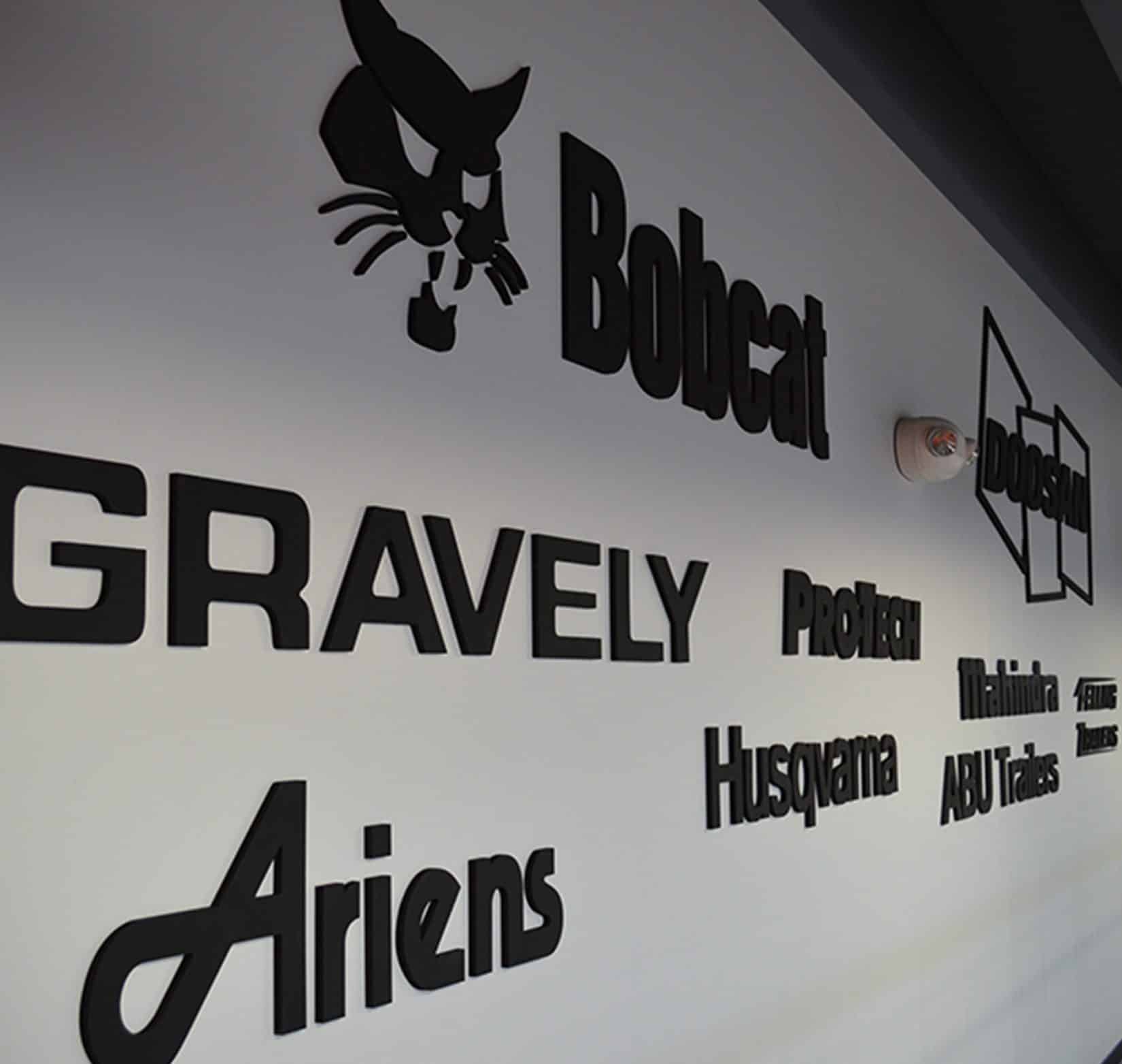 An assortment of company logos installed in black text on a white wall