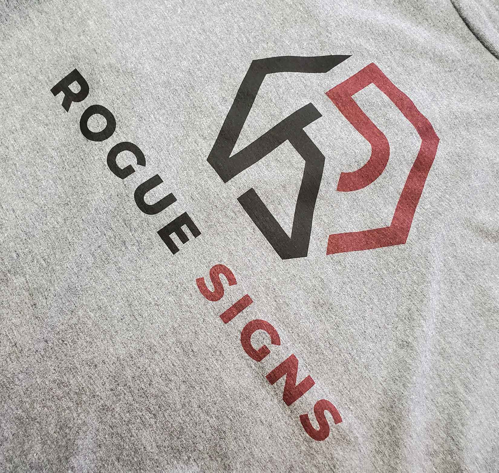 A gray t-shirt that reads rogue signs and has the company's logo.