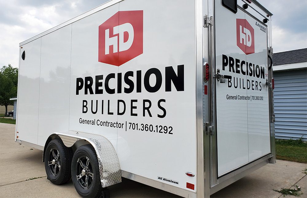 Vinyl lettering on a white trailer for Precision Builders
