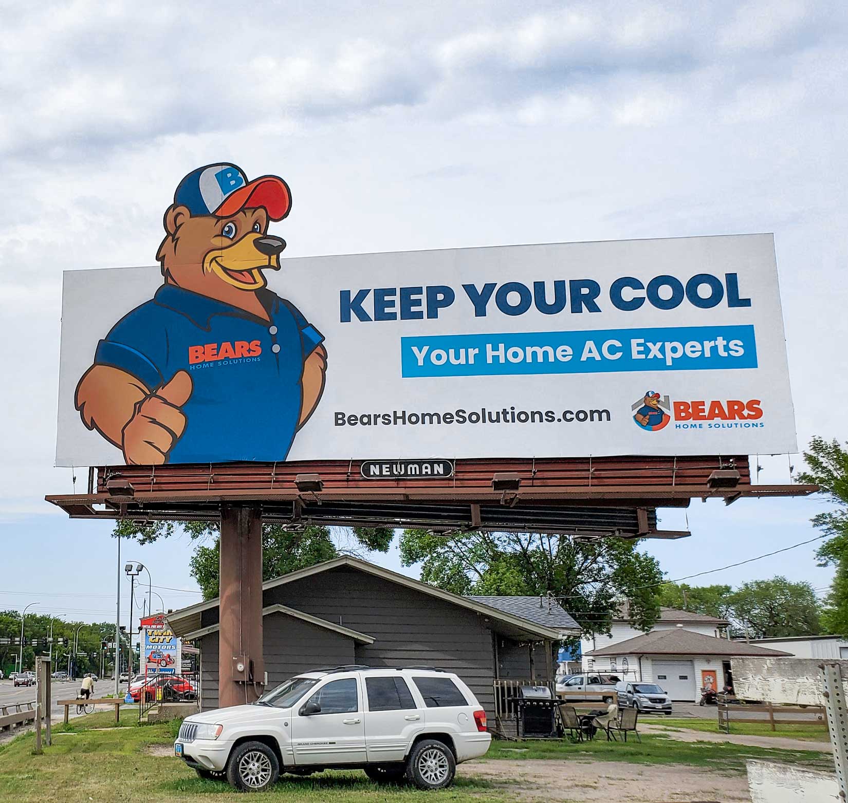 A static billboard promoting Bears Home Solutions’ air conditioning services along a main street in Grand Forks, ND